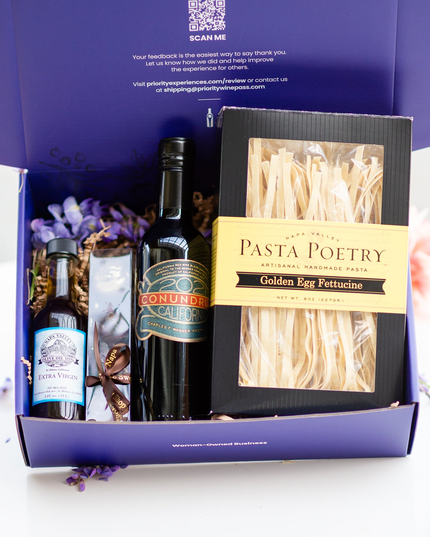 Gift box with pasta, olive oil, and wine on a white background